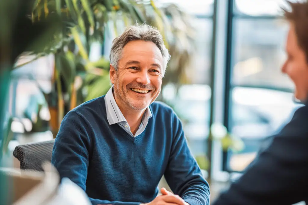 Experienced consultant advising a younger colleague in a meeting